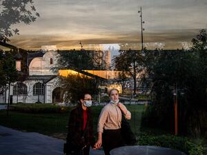 A couple wearing face masks enjoys a warm evening in central Moscow on October 5, 2020, amid the ongoing coronavirus disease (COVID-19) pandemic. Dimitar DILKOFF / AFP