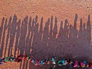 An aerial view taken on October 6, 2020, shows displaced Syrian youths standing in a queue ahead of classes, after tents were transformed to classrooms, at a camp for the internally displaced in the town Maarrat Misrin in Syria’s northwestern Idlib province. Omar HAJ KADOUR / AFP