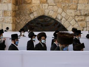 Ultra-Orthodox Jewish worshippers, wearing protective face masks, pray during the Sukkot holiday, or the feast of the Tabernacles, at the Western Wall in the old city of Jerusalem, on October 7, 2020, amid Israel's second-wave of Coronavirus lockdown. MENAHEM KAHANA / AFP