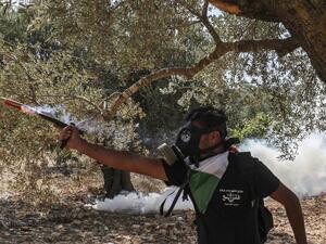 A mask-clad protester wearing a Fatah youth-labelled t-shirt shoots firecrackers during clashes between Palestinian protesters and Israeli forces following a demonstration against Jewish settlements in the town of Asira Shamaliya in the occupied West Bank near Nablus on October 9, 2020. ABBAS MOMANI / AFP