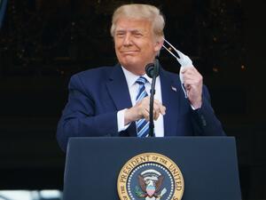 US President Donald Trump takes his mask off before speaking from the South Portico of the White House in Washington, DC during a rally on October 10, 2020. Trump spoke publicly for the first time since testing positive for Covid-19, as he prepares a rapid return to the campaign trail just three weeks before the election. MANDEL NGAN / AFP