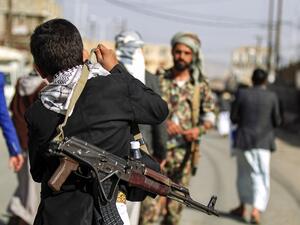 In this file photo a Yemeni boy adjusts on his shoulder the strap of a Kalashnikov assault rifle as he attends a demonstration in the Huthi rebel-held capital Sanaa on January 31, 2020, against a US-brokered proposal for a settlement of the Israeli-Palestinian Middle East conflict. Yemen's Huthi rebels on October 14, 2020 freed two captive Americans, the White House said, in what was reported to be a swap in which Saudi Arabia freed some of the group's supporters. "The United States welcomes the release tod