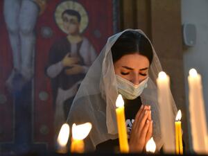 An Armenian woman, wearing a face mask, prays in a church in Yerevan on October 17, 2020, for Armenians killed during fighting over the breakaway region of Nagorno-Karabakh. Karen MINASYAN / AFP
