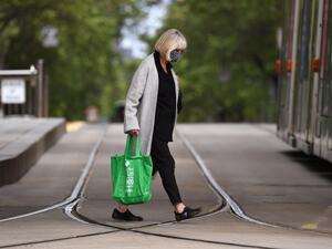 A woman crosses a street in Melbourne on October 18, 2020, as the state government announces a lifting of some restrictions as the city battles a second wave of the Covid-19 coronavirus. William WEST / AFP