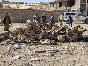 Security personnel and residents gather around the site of a car bomb attack that targeted an Afghan police headquarters in Feroz Koh, the capital of Ghor Province on October 18, 2020. A car bomb on October 18 targeting an Afghan police headquarters in the western province of Ghor killed at least 12 civilians and wounded more than 100, officials said. AFP