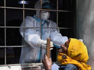 A health worker collects a swab sample from a resident to test for the Covid-19 coronavirus at a testing centre in New Delhi on October 19, 2020. Sajjad HUSSAIN / AFP