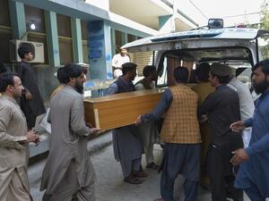 Relatives carry the coffin of a victim, who was killed in a stampede, outside a mortuary in Jalalabad on October 21, 2020. At least 11 women were killed on October 21 in a stampede at a stadium in eastern Afghanistan where thousands had gathered to apply for visas at a nearby Pakistan consulate, officials said. NOORULLAH SHIRZADA / AFP