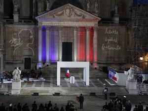 French President Emmanuel Macron, center, pays his respects in front of the coffin of Samuel Paty inside Sorbonne University's courtyard in Paris on October 21, 2020, during a national homage to French teacher Samuel Paty, who was beheaded for showing cartoons of the Prophet Mohamed in his civics class. Francois Mori / POOL / AFP