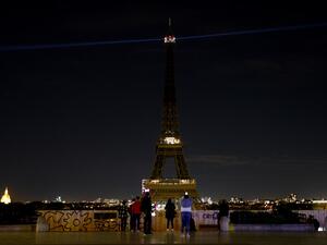 The lights of the Eiffel Tower in Paris are switched-off on October 21, 2020, during a national homage to French teacher Samuel Paty who was beheaded for showing cartoons of the Prophet Mohamed in his civics class. (AFP)
