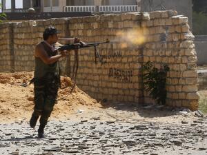 In this file photo taken on September 7, 2019, a fighter loyal to the internationally recognised Libyan Government of National Accord (GNA) fires his gun during clashes with forces loyal to strongman Khalifa Haftar in the capital Tripoli's suburb of Ain Zara. Libya's two warring factions signed a "permanent" ceasefire agreement following five days of talks at the United Nations. Mahmud TURKIA / AFP