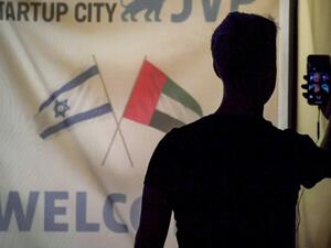 A member of an Israeli tech delegation uses his phone in a video call during an evening meeting with Emirati counterparts at a hotel in Dubai on October 25, 2020. (AFP)