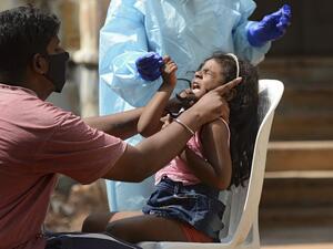 A girl reacts as a health worker wearing protective gear prepares to collect her swab sample to test for the Covid-19 coronavirus at sample collection centre in Hyderabad on October 29, 2020. India on October 29 passed eight million coronavirus cases, with the world's second-worst-hit country bracing for a possible second wave ahead of winter and a series of religious festivals. NOAH SEELAM / AFP