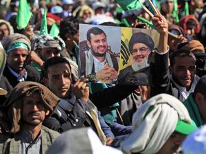 A Yemeni man holds up pictures of Huthi rebel leader Abdul-Malik al-Huthi (L) and chief of the Shiite Muslim movement Hezbollah Hassan Nasrallah during a ceremony marking the birth anniversary of Islam's Prophet Mohammad, known in Arabic as "Mawlid al-Nabawi", in the Yemeni capital Sanaa on October 29, 2020. Mohammed HUWAIS / AFP