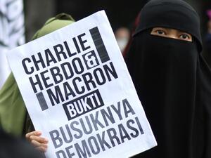 A Muslim demonstrator holds a placard during a protest against French President Emmanuel Macron for his comments over the Prophet Mohammed caricatures, in Bandung on October 30, 2020. Timur Matahari / AFP