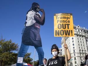 Protesters hold up a cardboard cutout during the Women’s March at Freedom Plaza on October 17, 2020 in Washington, DC. (AFP)