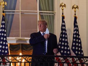 US President Donald Trump takes off his facemask as he arrives at the White House upon his return from Walter Reed Medical Center, where he underwent treatment for Covid-19, in Washington, DC, on October 5, 2020. NICHOLAS KAMM / AFP