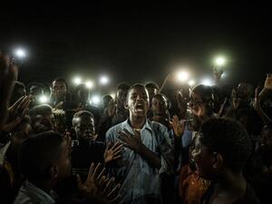 "A young man, illuminated by mobile phones, recites protest poetry while demonstrators chant slogans calling for civilian rule, during a blackout in Khartoum, Sudan." (AFP)