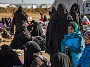 Women and children sit outdoors on the ground at the Kurdish-run al-Hol camp for the displaced in Hasakah province in northeastern Syria on Jan. 14, 2020, where families of Islamic State fighters are held. Photo by Photo by DELIL SOULEIMAN/AFP via Getty Images.