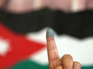 A Jordanian woman shows her ink-stained finger after voting Tuesday morning in the parliamentary elections. (AFP/Khalil Mazraawi)