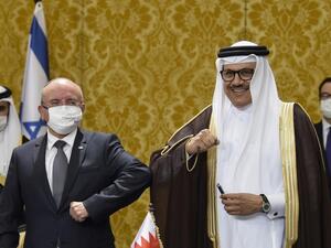 Bahraini Foreign Minister Abdullatif bin Rashid al-Zayani, right, and Israeli National Security Adviser Meir Ben Shabbat bump elbows after signing ceremony in Manama on 18 October (AFP/File photo)