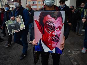 People hold caricatures of French President Emmanuel Macron during a demonstration on October 30, 2020 in Istanbul amid anger in the Islamic world over French President's defence of the right to publish cartoons seen as offencive to Islam. Yasin AKGUL / AFP