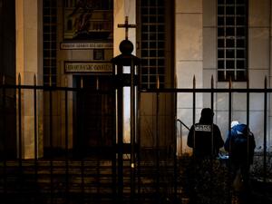 Police officers examine the entrance of the Orthodox Church where an attacker armed with a sawn-off shotgun wounded an Orthodox priest in a shooting before fleeing, on October 31, 2020 in Lyon, said a police source. (AFP/File)