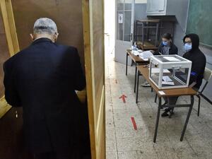 An Algerian man prepares to vote at a polling station in the capital Algiers during a vote for a revised constitution, on November 1, 2020. Polls opened in Algeria today for a vote on a revised constitution the regime hopes will neutralise a protest movement which at its peak last year swept long-time president Abdelaziz Bouteflika from power. RYAD KRAMDI / AFP