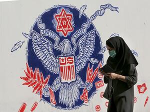 An Iranian woman walks past a mural painted on the outer walls of the former US embassy in the Iranian capital Tehran, on November 4, 2020 as the US waits for the results of the presidential election. ATTA KENARE / AFP