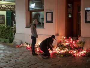 A couple light up some candles in front of a restaurant the place of the terrorist attack in Vienna, Austria on November 4, 2020. More details emerged on November 4, 2020 about the attacker who killed four on in Vienna before being shot dead by police, described as a "lost soul" of 20 already jailed once for support of the "Islamic State" (IS) group.  JOE KLAMAR / AFP