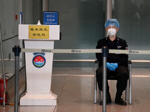 A security guard watches over the empty international arrivals channel at Beijing airport on November 6, 2020, after China banned foreign arrivals from France and a host of other countries, the latest in a growing number of entry bans as China closes itself off from a world still battling the coronavirus pandemic. GREG BAKER / AFP
