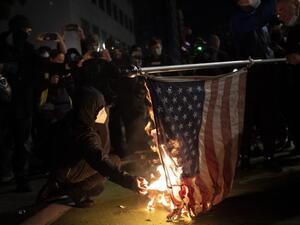 Black bloc protesters burn an American flag on November 4, 2020 in Portland, Oregon. Multiple protests, some peaceful and others violent, broke out in Portland as the presidential election remained undecided. Nathan Howard/Getty Images/AFP