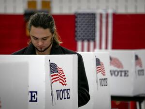 An maskless voter fills in his ballot on November 03, 2020 in Lansing, Michigan. After a record-breaking early voting turnout, Americans went to the polls on the last day to cast their vote for incumbent U.S. President Donald Trump or Democratic nominee Joe Biden in the 2020 presidential election. JOHN MOORE / GETTY IMAGES NORTH AMERICA / Getty Images via AFP