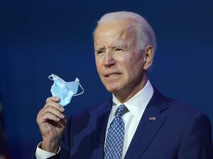 U.S. President-elect Joe Biden holds a protective mask as he speaks to the media after receiving a briefing from the transition COVID-19 advisory board on November 09, 2020 at the Queen Theater in Wilmington, Delaware. Mr. Biden spoke about how his administration would respond to the coronavirus pandemic. Joe Raedle/Getty Images/AFP JOE RAEDLE / GETTY IMAGES NORTH AMERICA / Getty Images via AFP
