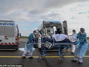 Medical staff take a patient to a waiting aircraft to be transported to another hospital in France, which is once again seeing hundreds of daily deaths linked to Covid-19 . (AFP/File)