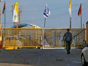 An Israeli soldier walking up to the gate of the Rosh HaNikra Crossing, also known as the Ras Al Naqoura Crossing, between Israel and Lebanon on Oct. 12, 2020. (AFP Photo)