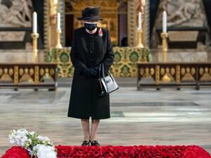 Britain's Queen Elizabeth II looks on as her Equerry, Lieutenant Colonel Nana Kofi Twumasi-Ankrah (L) places a bouquet of flowers at the grave of the Unknown Warrior to mark the centenary of the burial of the Unknown Warrior ahead of Remembrance Sunday at Westminster Abbey in London on November 4, 2020. (AFP)
