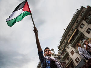 A Palestinian waves  flag (Shutterstock)