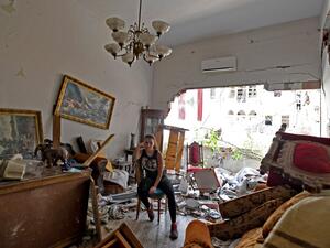 A woman sits amidst the rubble in her damaged house in the Lebanese capital Beirut on August 6, 2020. AFP