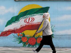 A woman walks while wearing a face mask amid the COVID-19 pandemic in the Iranian capital Tehran, on November 30, 2020. ATTA KENARE / AFP