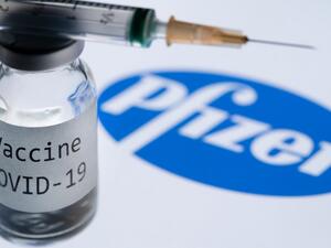 In this file photo taken on November 23, 2020 This illustration picture taken in Paris on November 23, 2020 shows a syringe and a bottle reading "Covid-19 Vaccine" next to the Pfizer company logo. Britain on December 2, 2020 became the first country to approve Pfizer-BioNTech's Covid-19 vaccine for general use and said it would be introduced next week. JOEL SAGET / AFP