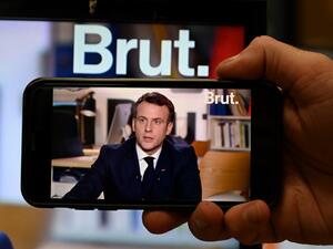 A journalist watches a live stream interview of French President Emmanuel Macron to the digital news platform Brut on December 4, 2020 in Paris. BERTRAND GUAY / AFP
