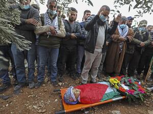Mourners pray around the body of Palestinian teenager Ali Abu Alia during his funeral in the village of Mughayir near Ramallah in the Israeli-occupied West Bank, on December 5, 2020. The Palestinian teenager was killed in clashes with the Israeli army on the sidelines of a protest in the occupied West Bank, the Palestinian health ministry said. ABBAS MOMANI / AFP