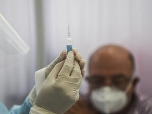 A health worker prepares a syringe to inoculate a volunteer with a COVID-19 vaccine produced by the Chinese Sinopharm during its trial at the Clinical Studies Center of the Cayetano Heredia University in Lima on December 09, 2020. ERNESTO BENAVIDES / AFP