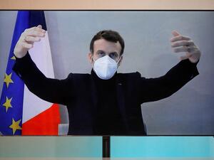French President Emmanuel Macron, tested positive for the coronavirus disease (COVID-19), is seen on a screen as he attends by video conference a round table for the National Humanitarian Conference (NHC) at the Foreign Ministry in Paris on December 17, 2020. A host of European leaders and top French officials rushed into isolation on December 17 after President Emmanuel Macron tested positive for Covid-19, upending political agendas across the continent. CHARLES PLATIAU / POOL / AFP