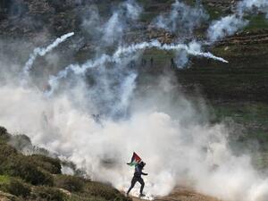 Palestinian protesters run for cover from tear gas canisters fired by Israeli security forces during a demonstration against the expansion of settlements near the West Bank village of Beit Dajan, east of Nablus, on December 18, 2020. JAAFAR ASHTIYEH / AFP