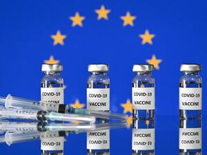 This illustration photo taken on November 17, 2020 shows vials with Covid-19 Vaccine stickers attached, and syringes, with a flag of the European Union. The EU's drug regulator authorised the Pfizer-BioNTech coronavirus vaccine on December 21, 2020, and said there was no evidence it would not work against a new strain found mainly in Britain. JUSTIN TALLIS / AFP