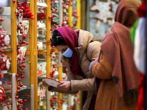 An Iranian woman, wearing a protective face mask, shops at a store selling Christmas decorations in the capital Tehran on December 22, 2020. ATTA KENARE / AFP