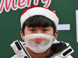A staff member wearing a face mask stands in a Christmas-themed booth in Seoul on December 23, 2020, as South Korea banned gatherings of more than four people in the capital and surrounding areas amid a surge in cases of the COVID-19 coronavirus. Jung Yeon-je / AFP