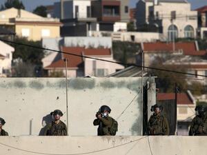 Israeli security forces keep watch as Palestinian youths throw stones during a protest in the village of Kfar Qaddum in the occupied West Bank, on December 26, 2020. JAAFAR ASHTIYEH / AFP