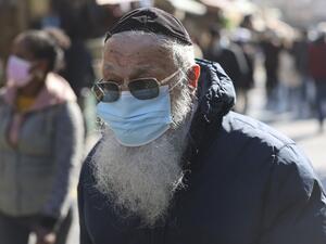 An ultra-Orthodox Jewish man walks clad in face mask along the Mahane Yehuda market in Jerusalem on December 27, 2020, before the start of a third lockdown due to the COVID-19 coronavirus pandemic. Israel is set to begin its third lockdown, as Prime Minister Benjamin Netanyahu voices optimism that a "world record" vaccination drive will restore a degree of normality within weeks. MENAHEM KAHANA / AFP